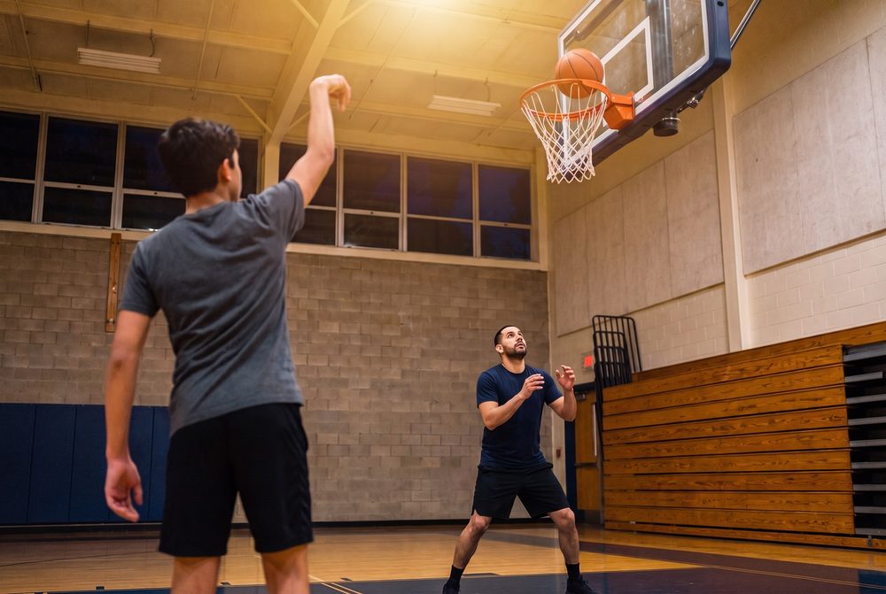 A player's free throw dropping through the net while Marcus waits to rebound